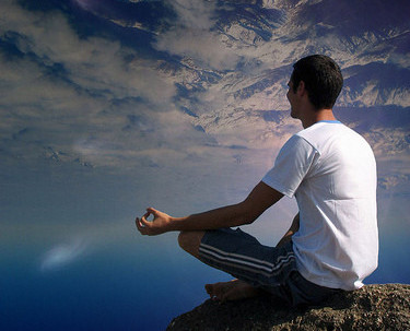 What is mindfulness? Image of peaceful man meditating on mountaintop