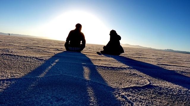 Peaceful image of 2 people sitting by Salt Lake, demonstrating how supporting others helps you support yourself
