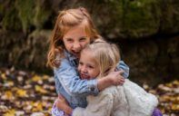 2 children hugging outdoors during playtime. connection helps promote mental health.